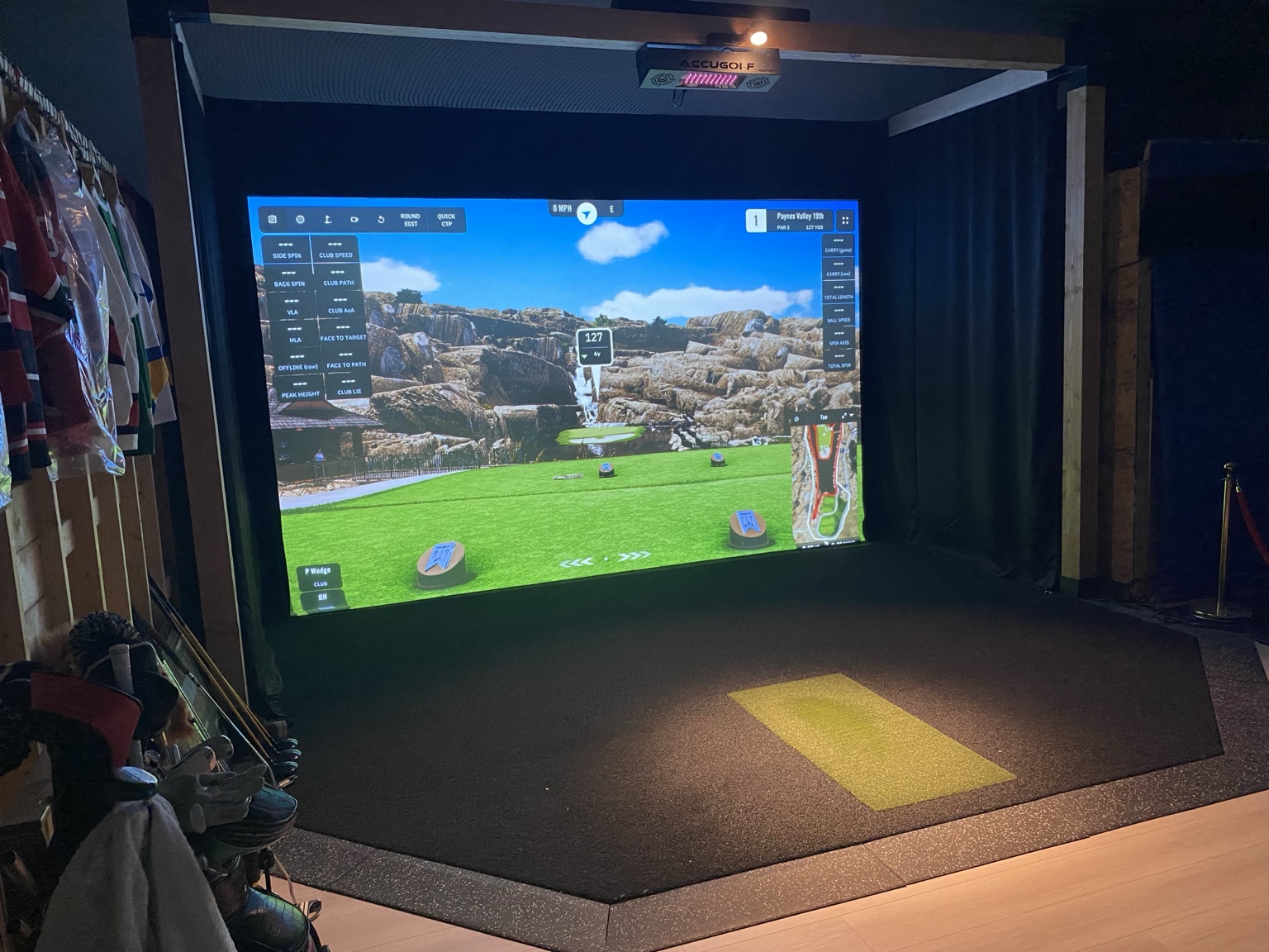 Actual Edges Golf simulator bay showing the projection screen, hitting mat and AccuGolf equipment